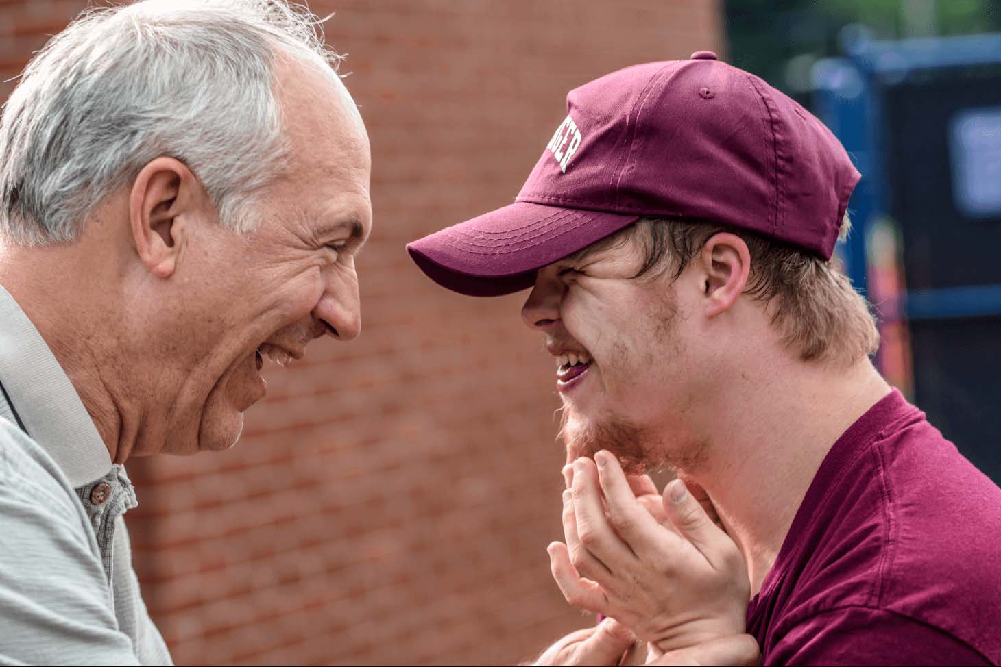 Two men laughing together in an outdoor environment.