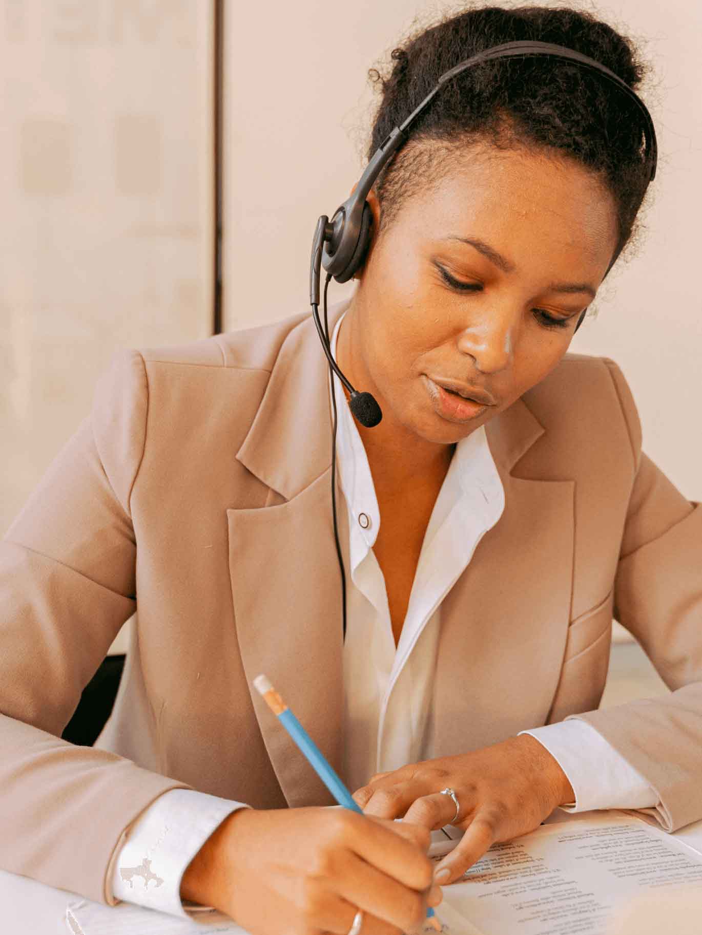 A woman with a headset sitting at a desk in an office